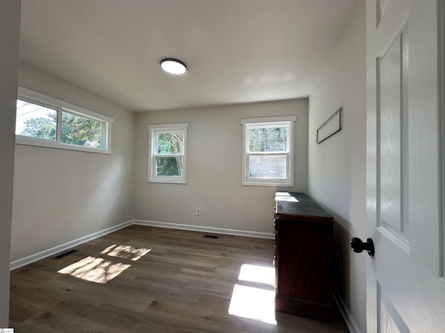 interior space featuring dark wood-style floors, visible vents, and baseboards