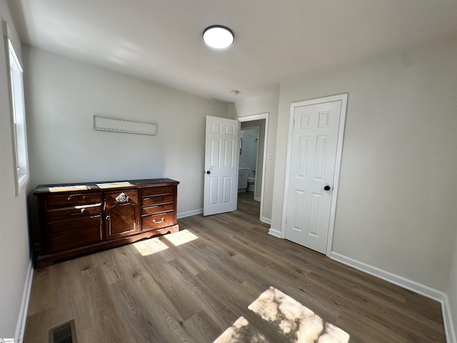 bedroom with light wood-style flooring, visible vents, and baseboards