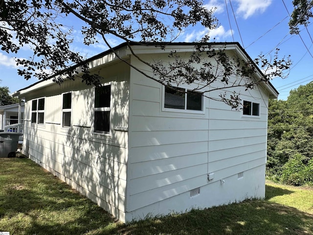 view of side of home featuring crawl space and a yard