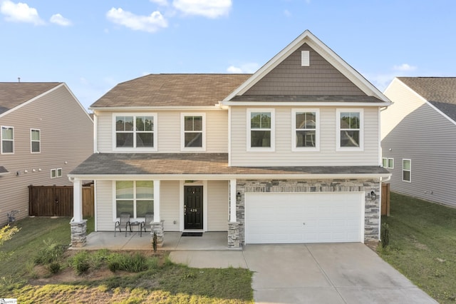 view of front of property featuring a porch, a front lawn, a garage, and concrete driveway