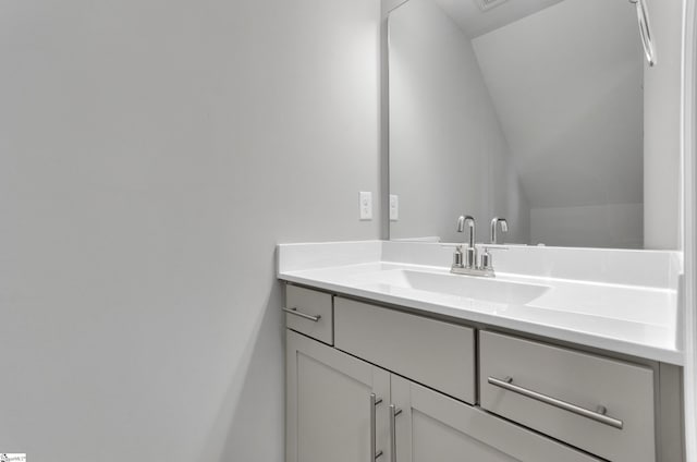 bathroom featuring vanity and lofted ceiling