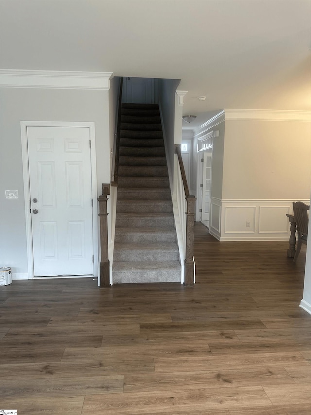 stairway with crown molding and hardwood / wood-style floors