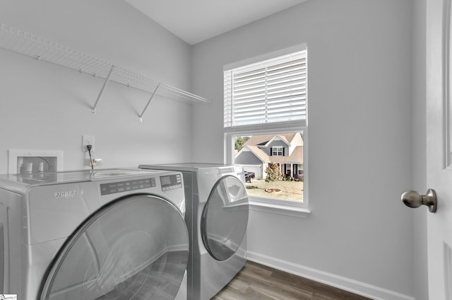 washroom with independent washer and dryer, wood finished floors, baseboards, and laundry area