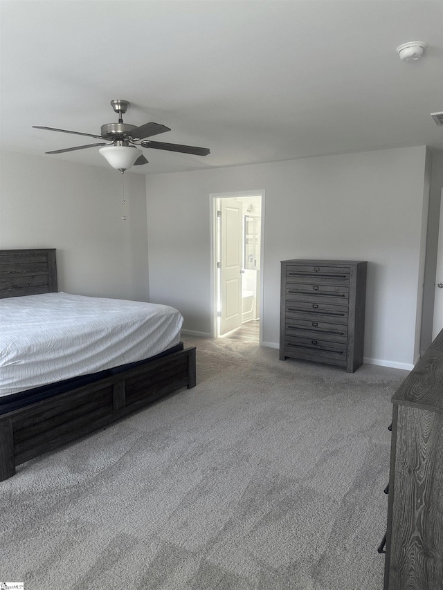 bedroom featuring ceiling fan, light colored carpet, and ensuite bathroom