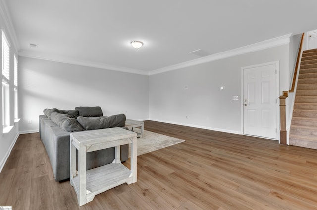 living area with baseboards, crown molding, stairs, and wood finished floors