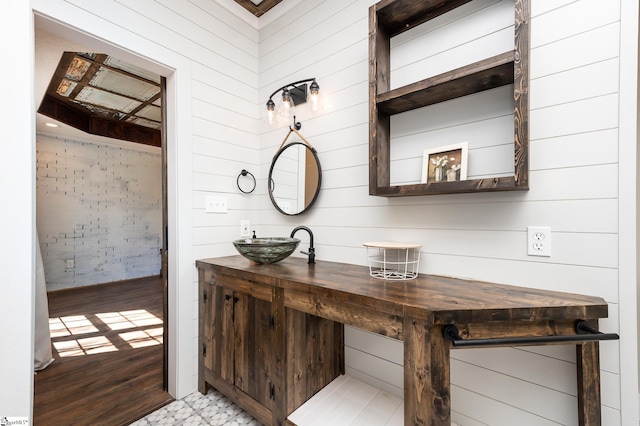 interior space featuring wooden walls, hardwood / wood-style floors, and vanity