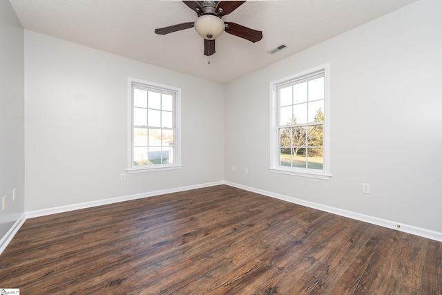 empty room featuring a textured ceiling, plenty of natural light, ceiling fan, and hardwood / wood-style flooring