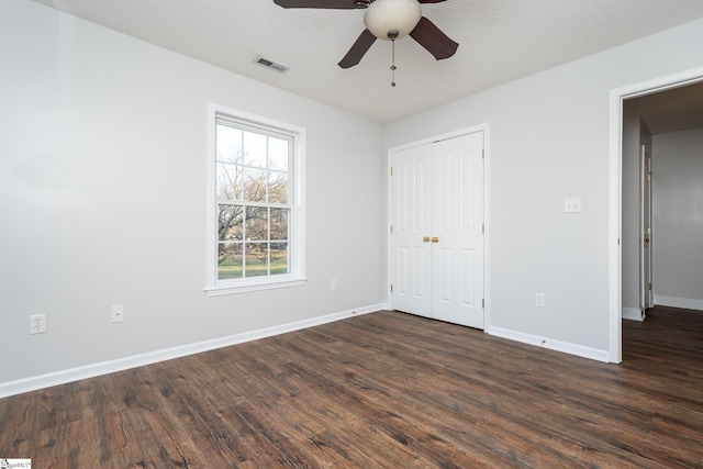 unfurnished bedroom featuring ceiling fan, a closet, a textured ceiling, and wood-type flooring