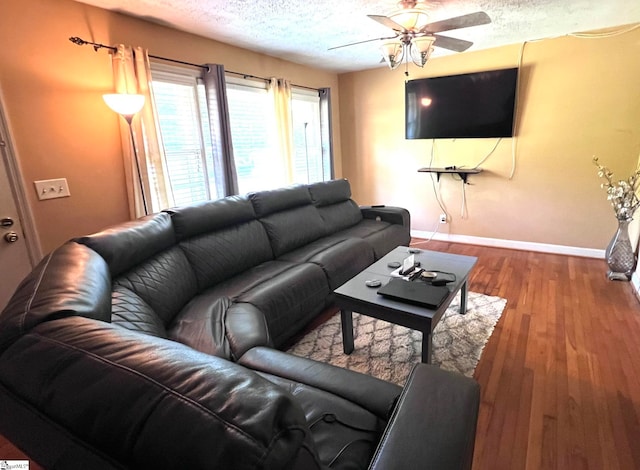 living room featuring ceiling fan, a textured ceiling, and hardwood / wood-style floors