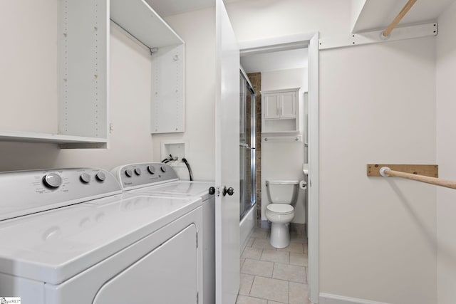 laundry area featuring washer and clothes dryer and light tile patterned floors