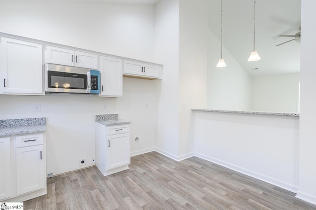 kitchen featuring white cabinets, light hardwood / wood-style flooring, and ceiling fan