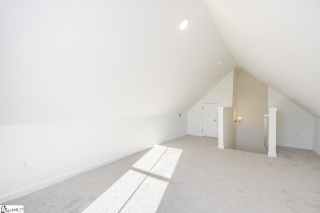 bonus room with light colored carpet and lofted ceiling