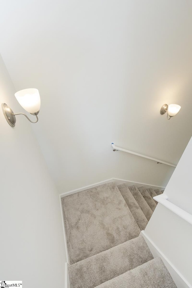 stairway featuring carpet flooring and lofted ceiling