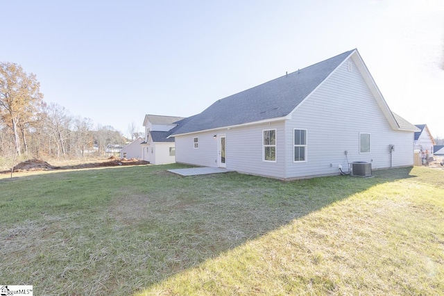 rear view of house featuring a lawn, central AC, and a patio