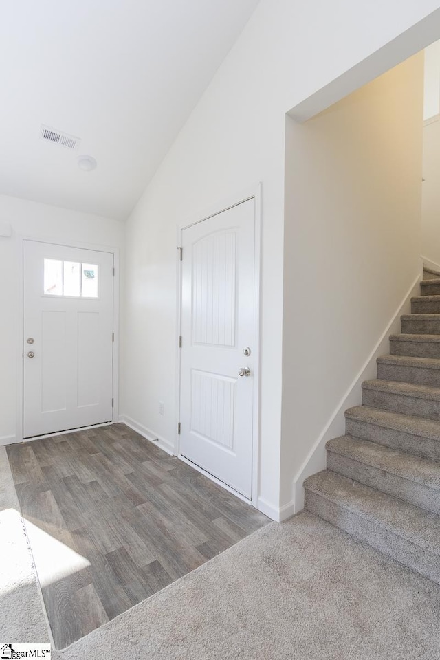 foyer entrance featuring wood-type flooring and vaulted ceiling