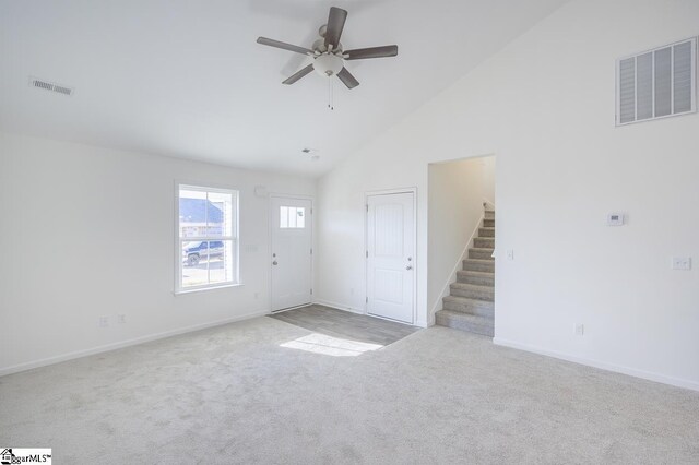 unfurnished living room with ceiling fan, light colored carpet, and high vaulted ceiling