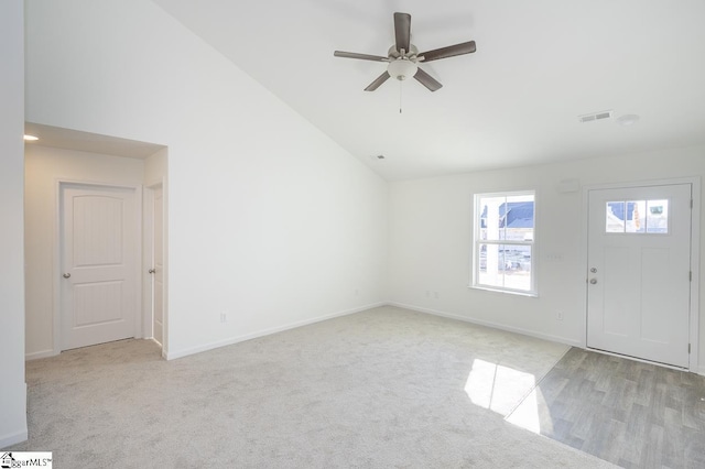 carpeted entrance foyer featuring vaulted ceiling and ceiling fan