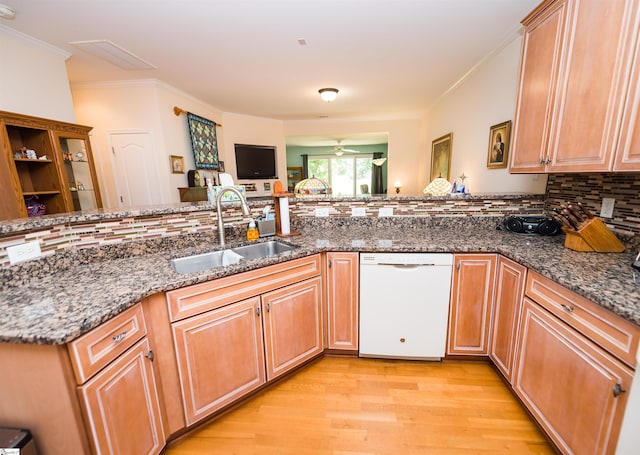 kitchen featuring dishwasher, tasteful backsplash, dark stone countertops, sink, and kitchen peninsula