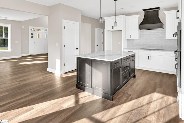 kitchen with custom range hood, white cabinetry, a center island, and dark hardwood / wood-style floors