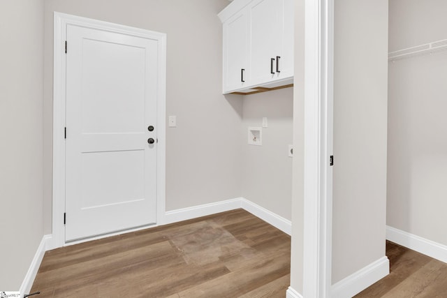 laundry room with electric dryer hookup, washer hookup, light wood-type flooring, and cabinets