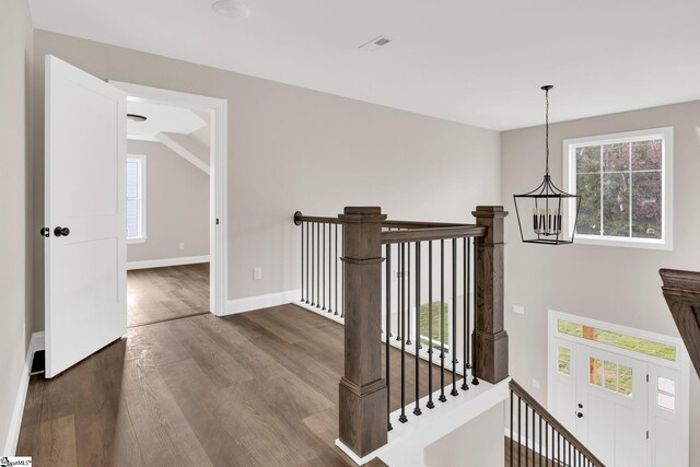 hallway featuring a notable chandelier and dark wood-type flooring