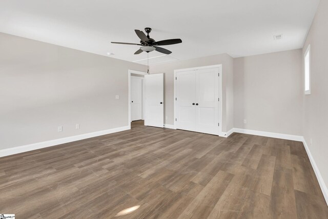 unfurnished bedroom featuring dark hardwood / wood-style flooring, a closet, and ceiling fan