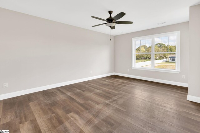 empty room with ceiling fan and dark hardwood / wood-style floors