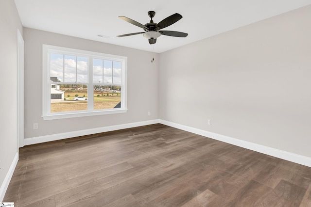 empty room with ceiling fan and dark hardwood / wood-style flooring