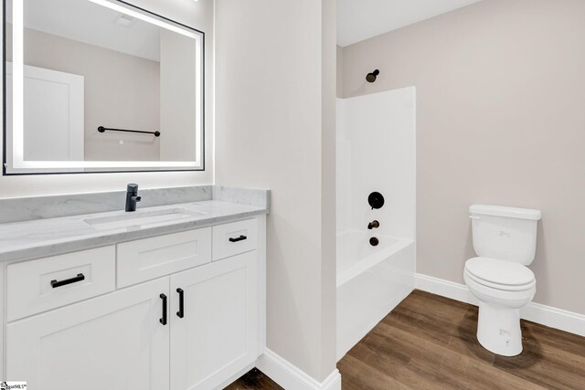 full bathroom with bathtub / shower combination, vanity, hardwood / wood-style floors, and toilet