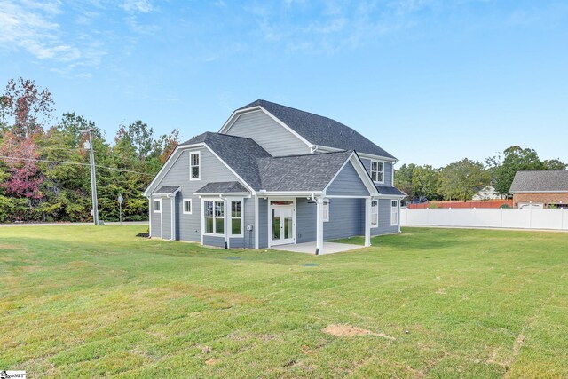 back of property with a yard and a patio area