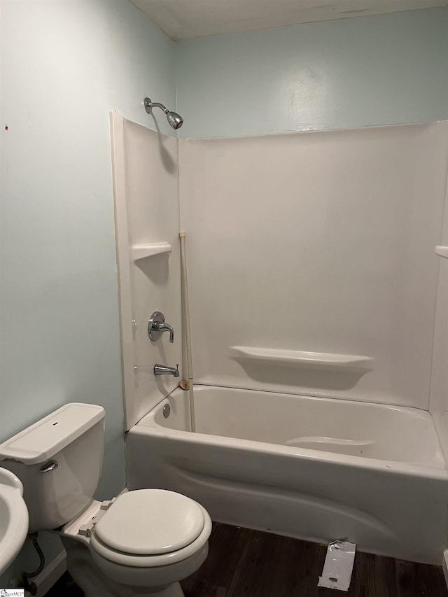 full bath with shower / washtub combination, toilet, and wood finished floors