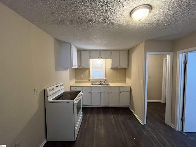 kitchen with dark wood-style floors, white range with electric cooktop, light countertops, a sink, and baseboards