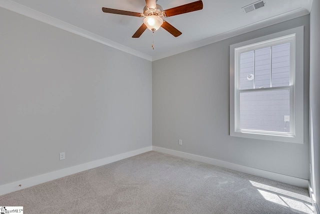 empty room featuring ceiling fan, carpet, and crown molding