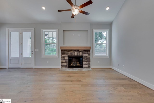 unfurnished living room with ceiling fan, light hardwood / wood-style flooring, and a healthy amount of sunlight