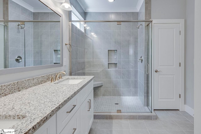 bathroom with crown molding, a shower with door, tile patterned flooring, and vanity