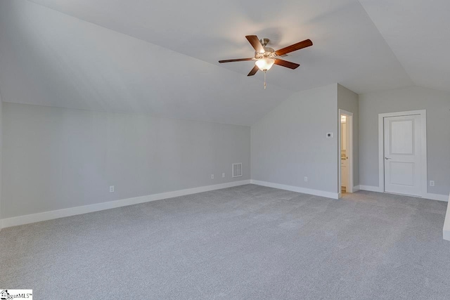 additional living space with ceiling fan, vaulted ceiling, and light colored carpet