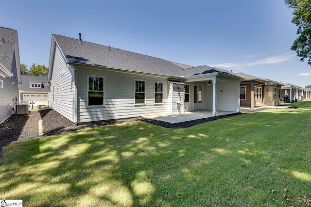 back of house with a lawn, central AC unit, a patio area, and a garage