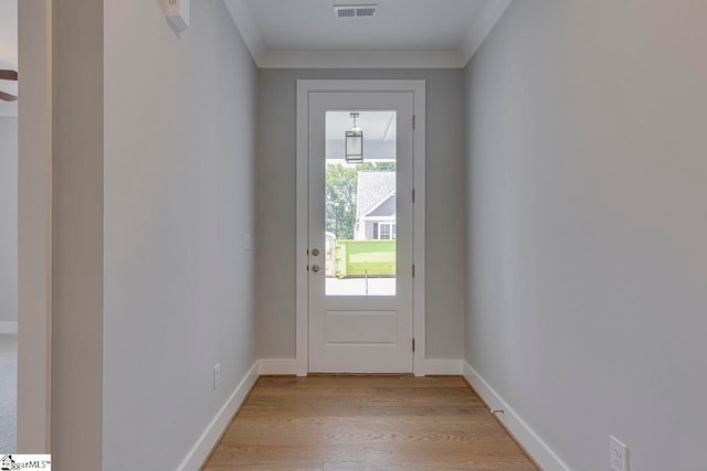 entryway with light hardwood / wood-style flooring and crown molding