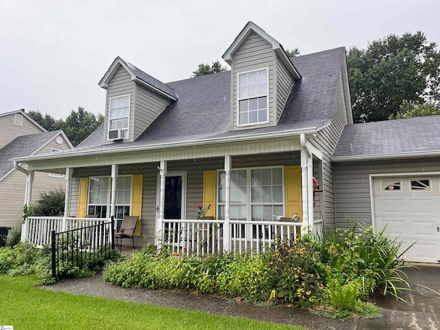 new england style home featuring covered porch and a garage