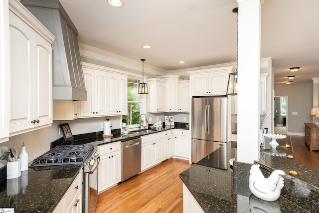 kitchen featuring decorative light fixtures, dark stone countertops, light hardwood / wood-style floors, and stainless steel appliances