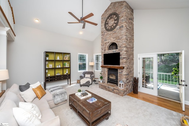 living room with a fireplace, light hardwood / wood-style flooring, high vaulted ceiling, and ceiling fan