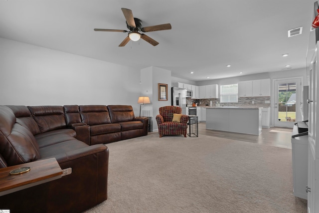 carpeted living room featuring ceiling fan