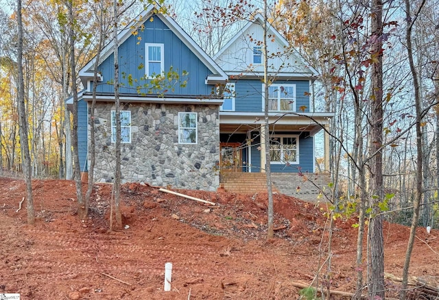 back of property with board and batten siding and stone siding