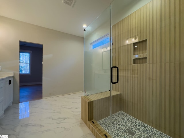 bathroom with marble finish floor, a shower stall, visible vents, and vanity