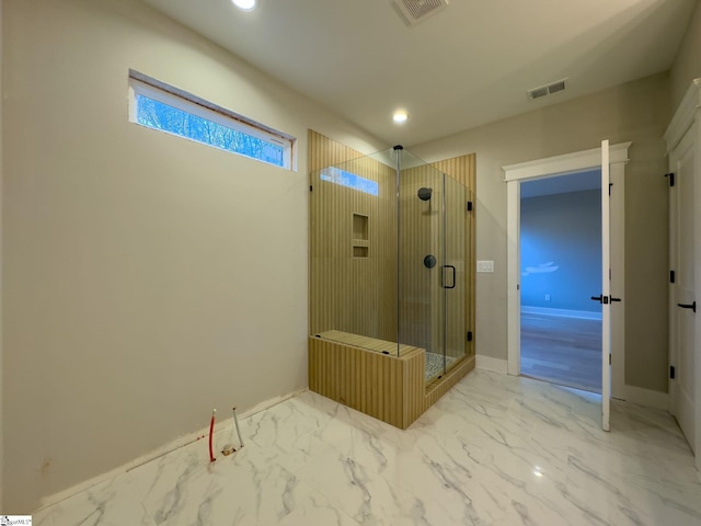 bathroom featuring marble finish floor, visible vents, a shower stall, and baseboards