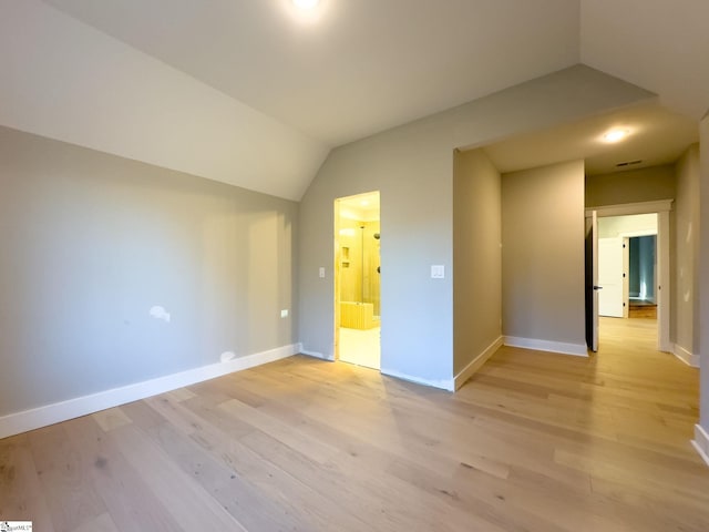 bonus room featuring light wood-style floors, baseboards, and vaulted ceiling