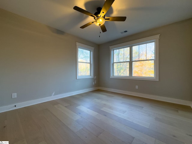 unfurnished room with light wood-style floors, visible vents, ceiling fan, and baseboards