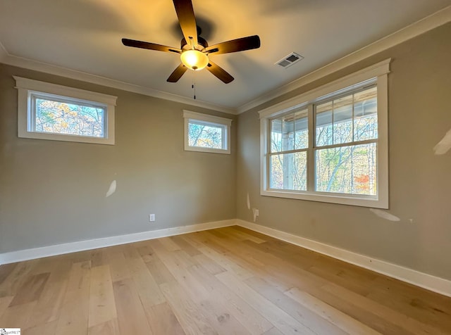 spare room with visible vents, crown molding, light wood-style flooring, and baseboards