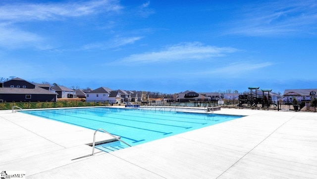 pool featuring a patio, fence, and a residential view