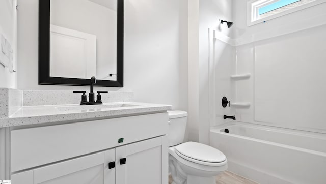 bathroom with toilet, vanity,  shower combination, and wood finished floors